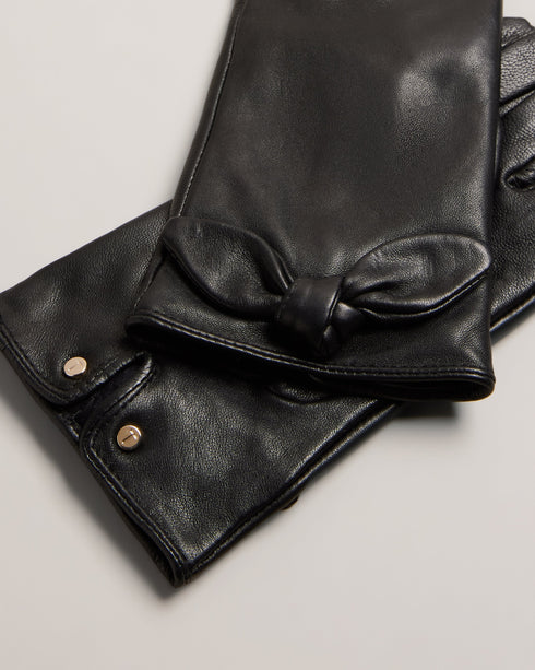 SOPHIIS-Gloves-Embrace the finer things in life with our beautifully crafted SOPHIIS gloves. Adorned with a charming knotted bow, they're a simple yet elegant way to warm up your look. Gloves Top grain leather Knotted bow embellishment Notched edge with magnolia studs- Ted Baker Romania